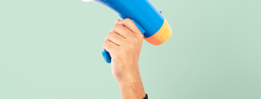 A hand in appearing from the bottom of the image holding a loudspeaker